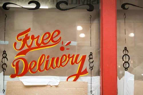 An image of a store with free delivery sign on its glass wall